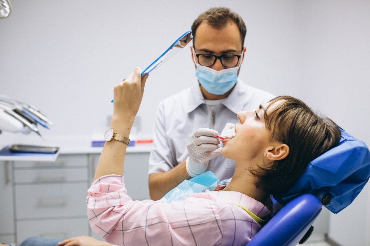 Imagem de uma mulher fazendo uma consulta no dentista