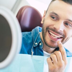 imagem homem verificando sorriso na cadeira do dentista