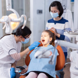 imagem de uma menina acompanhada de sua mãe durante a consulta ao dentista