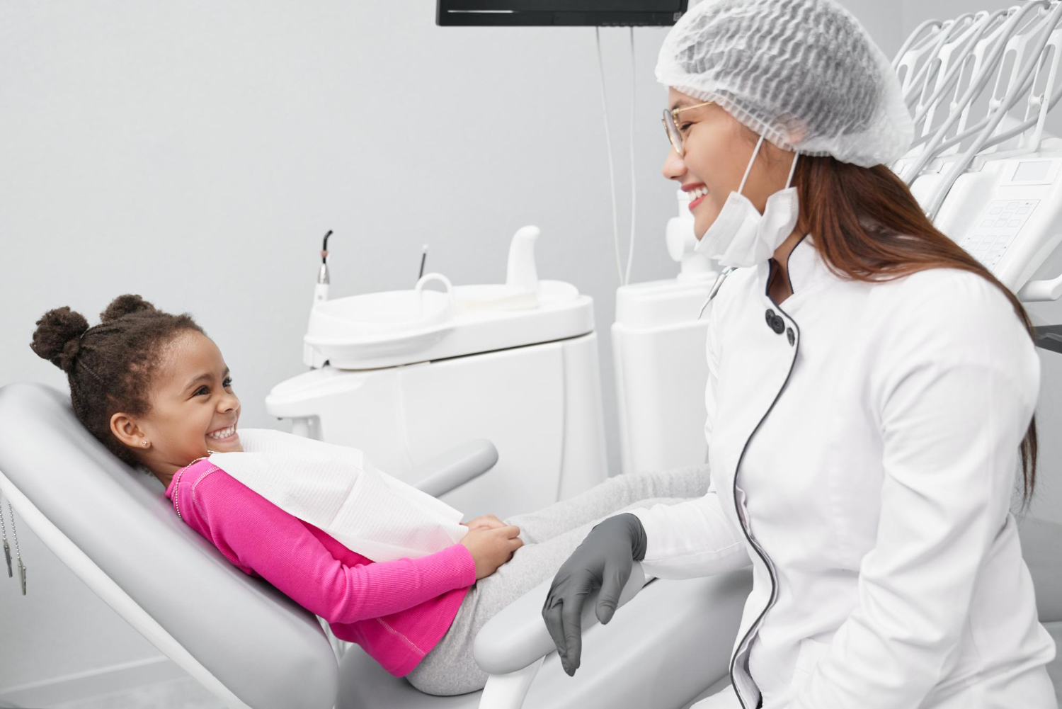 imagem de menina olhando para dentista feminina e rindo na clínica