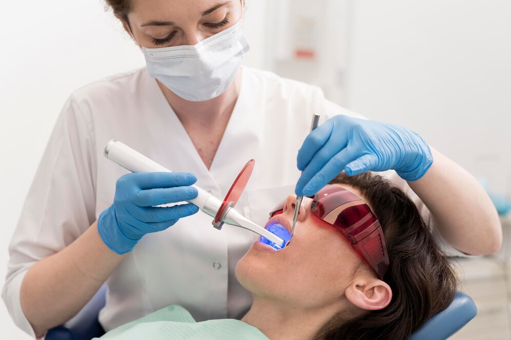 A imagem mostra um exemplo de uma porfissional usando um laser odontológico.