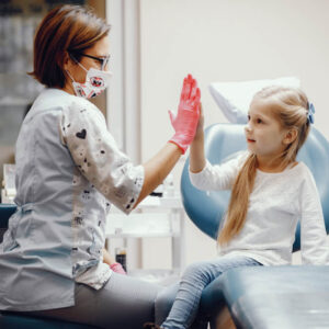 Menina sentada no loirinha consultório do dentista