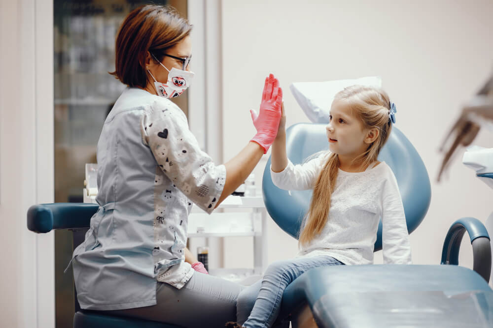 Menina sentada no loirinha consultório do dentista